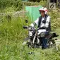 Presiden Joko Widodo mengendarai motor trail melintasi perkampungan di  Muara Gembong, Bekasi (1/11). Jokowi menghadiri kegiatan Perhutanan Sosial untuk Pemerataan Ekonomi. (Liputan6.com/Biro Pers Kepresidenan/Agus Suparto)