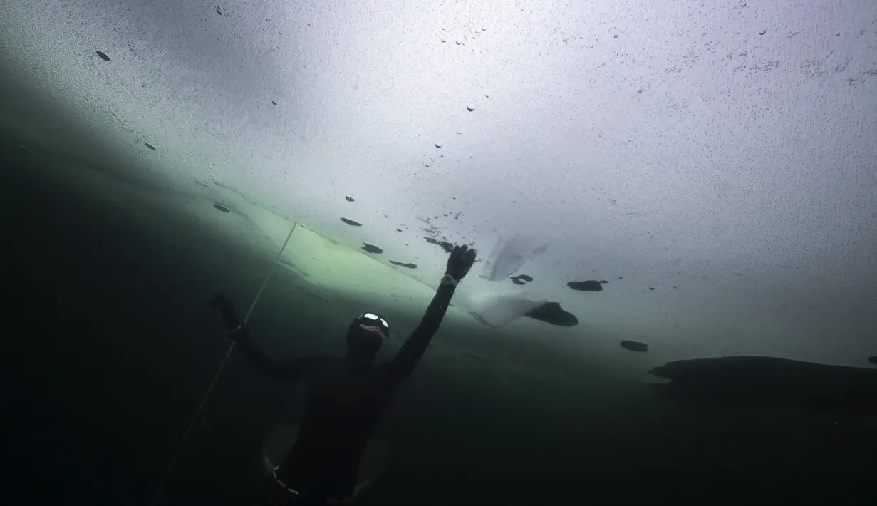 Johanna Nordblad menyelam di danau beku, Somero, Finlandia, Selasa (27/2). Johanna Nordblad memegang rekor dunia freediving di bawah es dengan baju renang sejauh 50m. (AFP PHOTO / Olivier Morin)