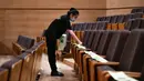 Seorang staf memasang instruksi jaga jarak di kursi-kursi penonton di Tianjin Grand Theater di Tianjin, China pada 28 Juli 2020. Gedung pertunjukan teater itu telah memulai proses disinfeksi menyeluruh selama sepekan sejak Senin (27/7) sebelum dibuka kembali untuk pengunjung. (Xinhua/Sun Fanyue)