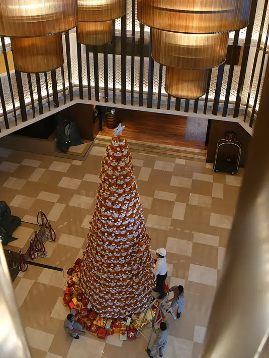 Seorang staff menyusun pohon Natal yang terbuat dari boneka beruang teddy di lobi sebuah hotel di Bangalore, India, Rabu (28/11). Ratusan boneka beruang disusun sedemikian rupa hingga membentuk pohon natal cantik. (MANJUNATH KIRAN / AFP)