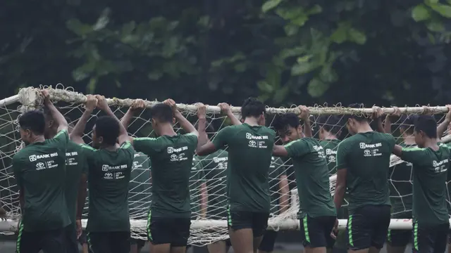 Para pemain Timnas Indonesia U-22 gotong royong mengangkat gawang. (Bola.com/Vitalis Yogi Trisna)