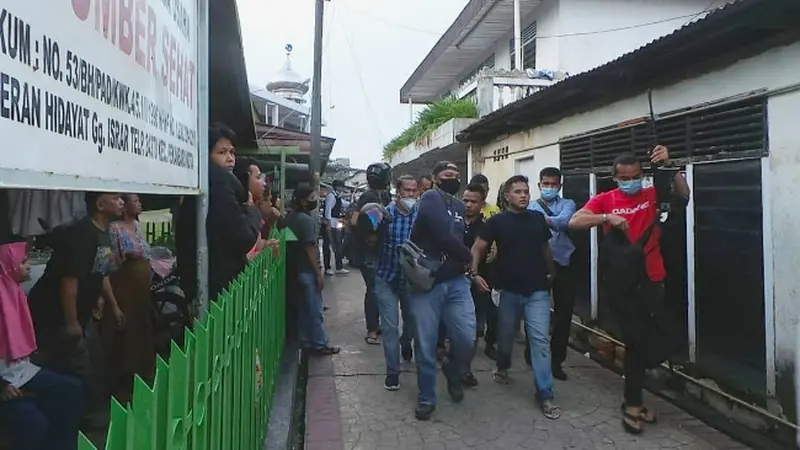 Personel Polresta Pekanbaru menggiring terduga pengedar narkoba yang membuat sejumlah warga melawan.