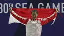 Lifter Aisyah Windy mengibarkan bendera saat naik podium usai mendapatkan medali emas SEA Games 2019 cabang angkat besi nomor 49 kg di Stadion Rizal Memorial, Manila, Minggu (1/12). Dirinya meraih emas dengan total angkatan 104 kg. (Bola.com/M Iqbal Ichsa