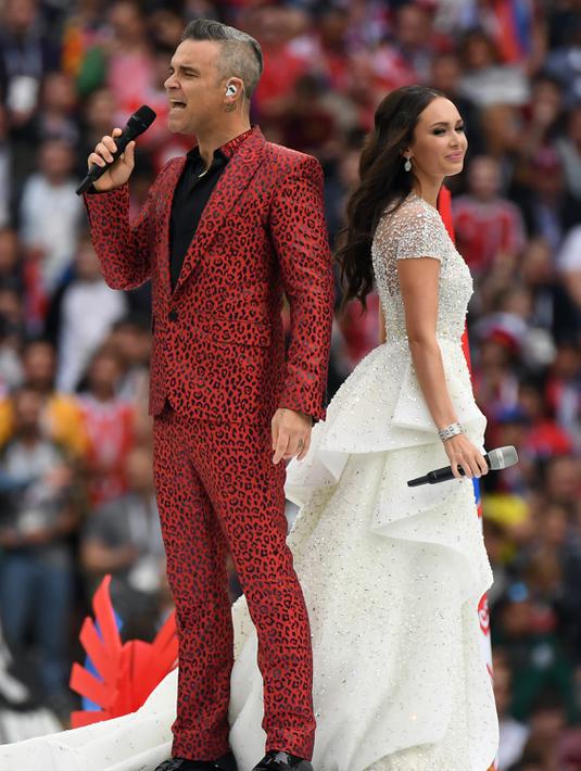 Penyanyi Rusia, Aida Garifullina, duet bersama penyanyi Inggris, Robbie Williams, saat pembukaan Piala Dunia di Stadion Luzhniki, Moskow, Kamis (14/6/2018). Laga pembuka Piala Dunia 2018 mempertemukan Rusia melawan Arab Saudi. (AFP/Kiril Kudryavtsev)