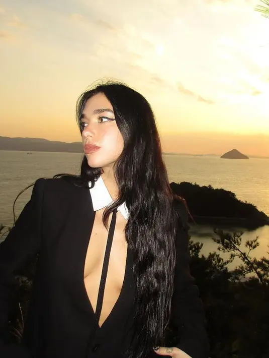 Pada bagian collar terdapat aksen dasi panjang yang membuat penampilannya semi maskulin. [instagram/dualipa]