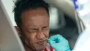 Staf medis mengambil sampel usap (swab) seorang pria di dalam kendaraan untuk tes COVID-19 di Shah Alam, Negara Bagian Selangor, Malaysia (12/12/2020). Malaysia melaporkan 1.937 kasus baru COVID-19, menambah total kasus di negara tersebut menjadi 82.246. (Xinhua/Chong Voon Chung)