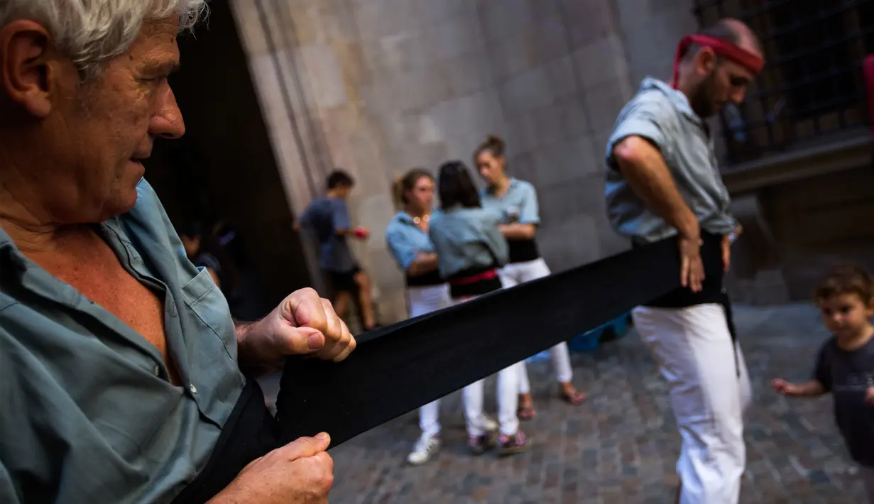 Dua Castellers bersiap-siap mengambil bagian dalam Castell di alun-alun Sant Jaume, Barcelona, Spanyol, Minggu (24/9). Dalam aksi ini, kelompok akar rumput telah membagikan satu juta kartu suara referendum kemerdekaan. (AP Photo/Emilio Morenatti)