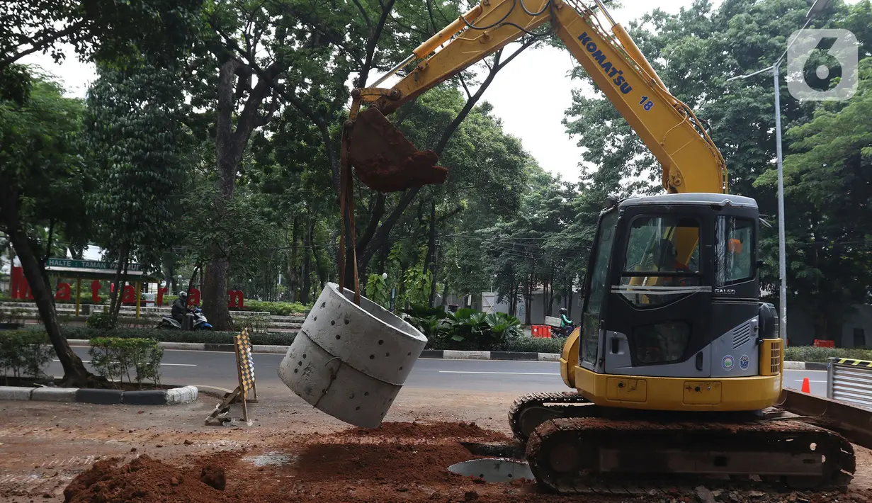 Pekerja sedang menyelesaikan pengerjaan sumur resapan di Jalan Mataram Raya, Kebayoran Baru, Jakarta, Selasa (12/10/2021). Pemerintah Provinsi (Pemprov) DKI Jakarta tengah mempercepat pembangunan sumur resapan yang ditargetkan terbangun di 22.292 titik. (Liputan6.com/Herman Zakharia)