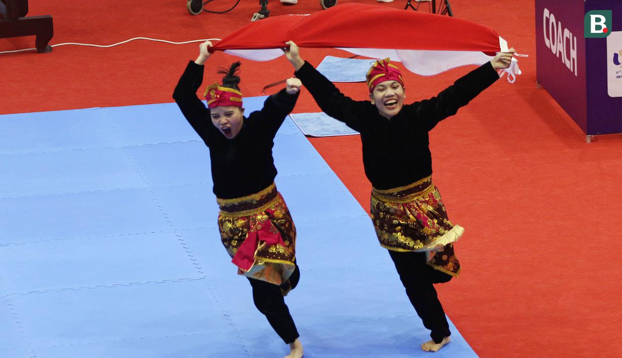 Selebrasi pesilat Indonesia Riska Hermawan dan Ririn Rinasih usai memenangkan nomor Seni Ganda Wanita Pencak Silat Sea Games 2021 Vietnam di Bac tu Liem Sport Center, Hanoi, Rabu (11/5/2022). (Bola.com/Ikhwan Yanuar)