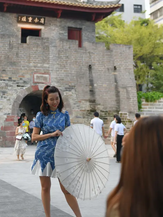 Seorang turis berpose di kota kuno Nantou di Distrik Nanshan, Shenzhen, Provinsi Guangdong, China selatan (29/8/2020). Dengan sejarah hampir 1.700 tahun, kota kuno Nantou kini menjadi objek wisata. (Xinhua/Mao Siqian)