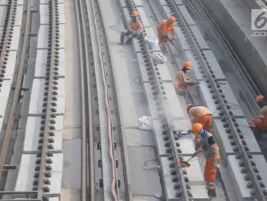 Pekerja menyelesaikan Rel Light Rail Transit (LRT) di Jakarta, Selasa (26/2). Light Rail Transit (LRT) Jabobek trase Cawang–Cibubur bakal diujicoba pada pertengahan tahun ini. (Liputan6.com/Herman Zakharia)