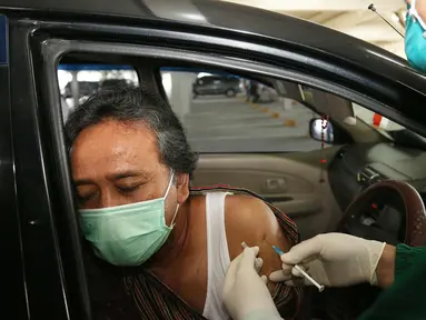 Lansia menerima suntikan vaksin COVID-19 di Sentra Vaksinasi Indonesia Bangkit secara drive thru di Rumah Sakit Universitas Indonesia, Depok, Jawa Barat, Senin (5/4/2021).  Vaksinasi untuk kalangan lanjut usia (lansia) di Indonesia terbilang lambat. (Liputan6.com/Angga Yuniar)