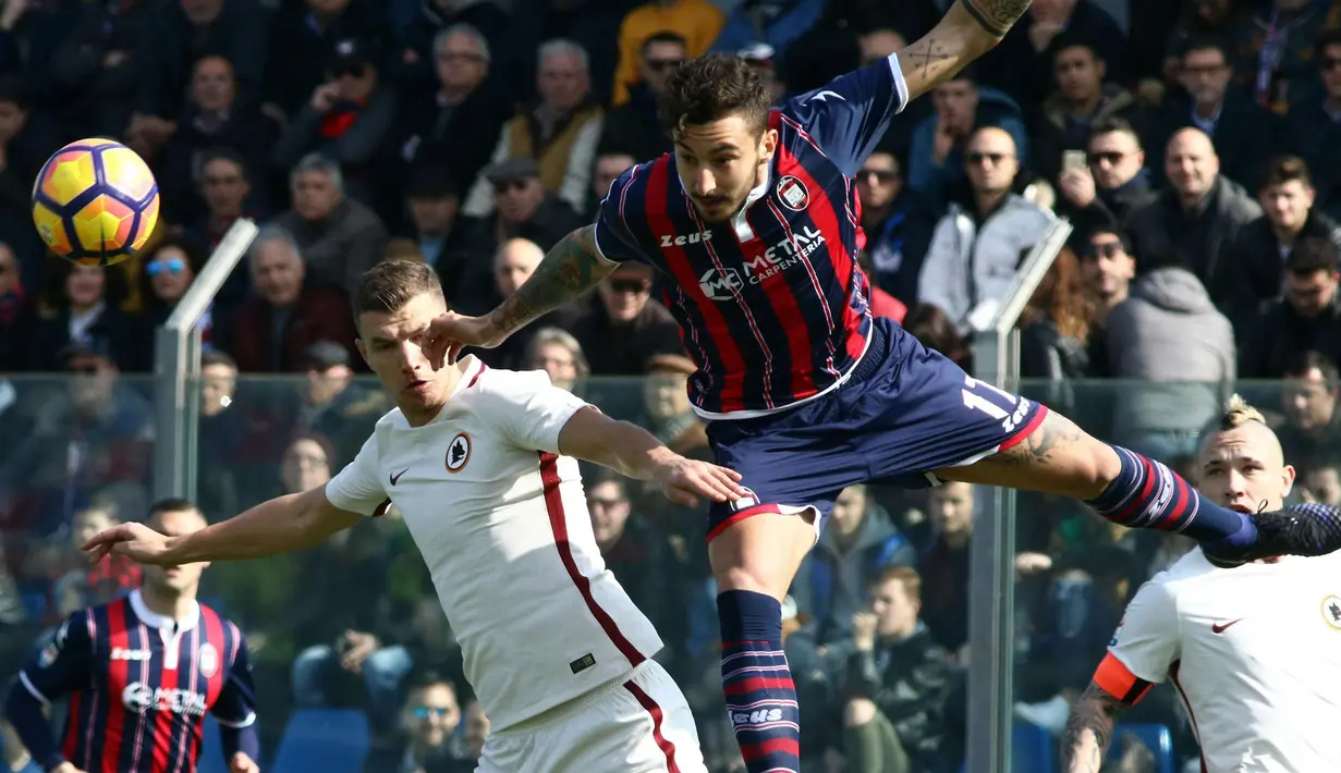 Pemain Crotone, Federico Ceccherini (kanan) menghalau bola dari kejaran pemain AS Roma, Edin Dzeko pada lanjutan Serie A di Ezio Scida stadium, Crotone, Italy (12/2/2017).  AS Roma menang 2-0. (Albano Angilletta/ANSA via AP)