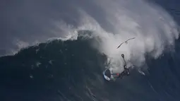 Aksi pesalancar Kealii Mamala menaklukan ombak di Praia do Norte, Nazare, Portugal, (13/11). Nazare Canyon memiliki kedalaman lebih dari 3 mil di bawah permukaan sehingga mampu menaikkan gelombang setinggi 100 sampai 150 kaki. (REUTERS/Rafael Marchante)