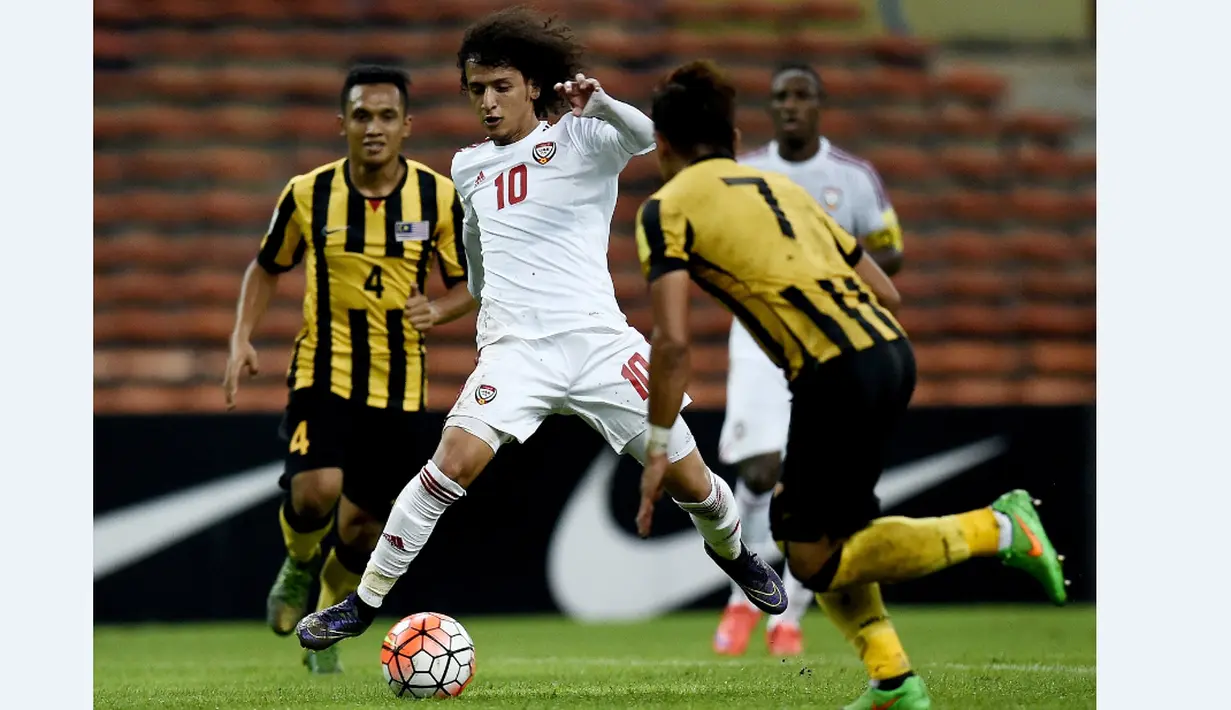 Pemain UEA, Omar Abdulrahman (tengah), berusaha melewati hadangan pemain Malaysia dalam Kualifikasi Piala Dunia 2018 di Stadion Shah Alam, Malaysia, (17/11/2015). Malaysia kalah 1-2 dari UEA. (AFP Photo/Manan Vatsyayana)