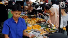 Pedagang melayani pembeli takjil menjelang waktu berbuka puasa di sepanjang Jalan Panjang, Kebon Jeruk, Jakarta, Selasa (4/4/2023). (Liputan6.com/Johan Tallo)