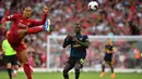 Bek Liverpool, Virgil van Dijk, membuang bola saat melawan Arsenal pada laga Premier League di Stadion Anfield, Liverpool, Sabtu (24/8). Liverpool menang 3-1 atas Arsenal. (AFP/Ben Stansall)