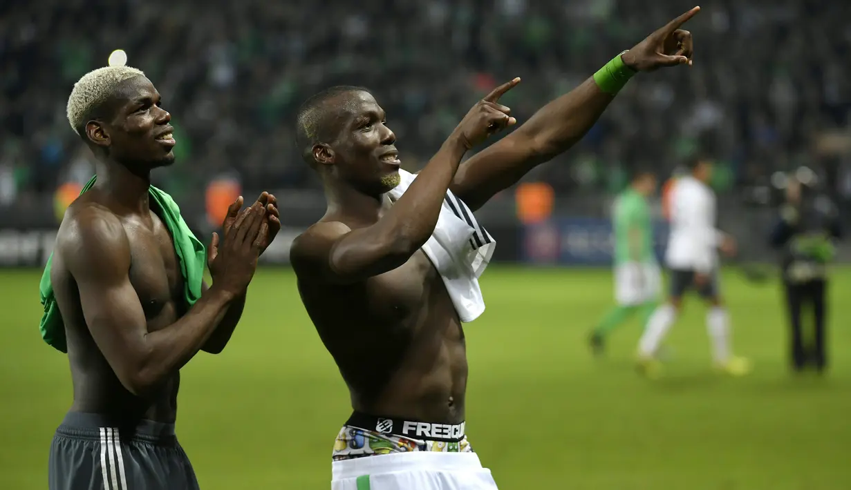 Gelandang Manchester United Paul Pogba (kiri) dan bek Saint-Etienne Florentin Pogba menyapa keluarga mereka usai pertandingan Liga Europa antara Manchester United melawan Saint-Etienne, di Stade Geoffroy-Guichard, Rabu (22/2). (PHILIPPE DESMAZES/AFP)