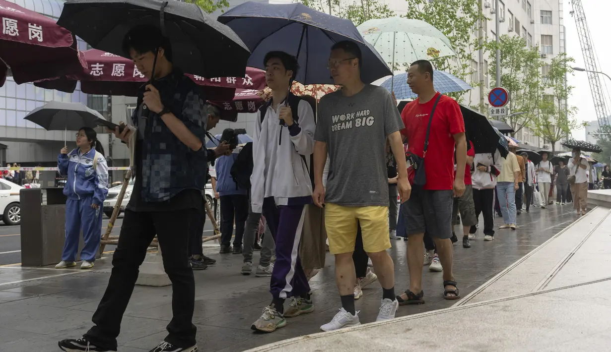 Dengan hujan yang meredakan panasnya musim panas di Beijing pada Jumat pagi, puluhan ribu siswa menuju ke tempat-tempat untuk mengikuti ujian masuk perguruan tinggi nasional China tahun 2024. (AP Photo/Ng Han Guan)