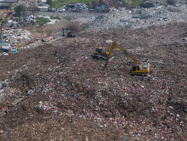 Alat berat eskavator  meratakan gunungan sampah di tempat Pembuangan Sampah Akhir (TPA) Burangkeng, Bekasi, Jawa Barat, Senin (6/5/2024). TPA Burangkeng rencananya akan memperluas lahan pembuangan sampah. (merdeka.com/Imam Buhori)