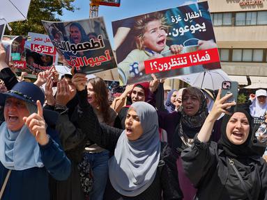 Warga Arab Israel memegang plakat dan meneriakkan slogan-slogan dalam aksi protes di dekat Kedutaan Besar Mesir di Tel Aviv pada 31 Juli 2025. (Jack GUEZ/AFP)