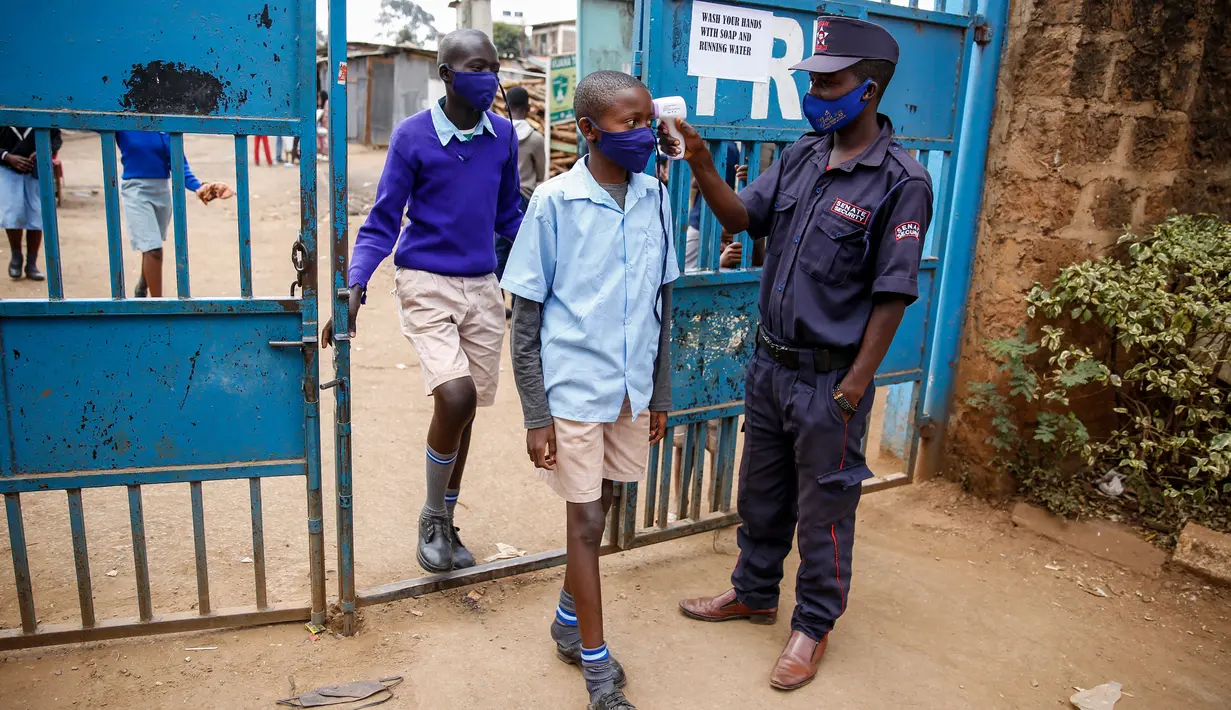 Petugas mengukur suhu tubuh siswa setibanya mereka di Sekolah Dasar Olympic di Kibera, salah satu daerah termiskin di ibu kota Nairobi, Kenya, Senin (12/10/2020). Kenya membuka kembali sebagian sekolah setelah ditutup sejak Maret lalu akibat pandemi corona COVID-19. (AP Photo/Brian Inganga)
