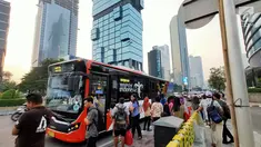 Warga menaiki angkutan umum di tepi Jalan Jenderal Sudirman, Jakarta, Senin (8/7/2019). Tidak adanya halte menyebabkan warga terpaksa menunggu angkutan umum di tempat seadanya. (Liputan6.com/Immanuel Antonius)