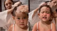 Seorang ibu mengoleskan minyak kemiri ke rambut putrinya (@cokmirahbiya/tiktok.com).