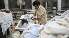 Seorang tukang cuci mencuci pakaian di binatu terbuka, yang secara lokal disebut 'Dhobi Ghat' di New Delhi, India pada 14 Maret 2022. Dhobi Ghat adalah tempat yang menyediakan layanan cuci dengan cara tradisional. (Money SHARMA / AFP)