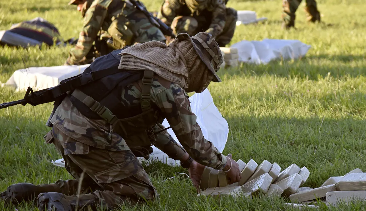 Petugas meletakan satu ton kokain dalam paket yang disita di lokasi Baures saat jumpa pers di Trinidad, El Beni, Bolivia (19/7). Obat terlarang tersebut diduga akan dikirim ke Brasil. (AFP Photo/Ar/Aizar Raldes)