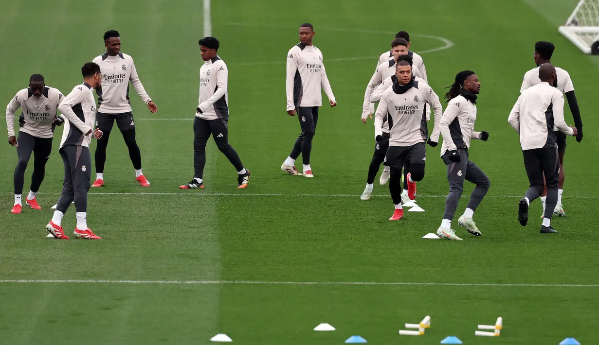 Para pemain Real Madrid melakukan pemanasan saat berlatih menjelang pertandingan babak 16 besar Liga Champions 2024/2025 melawan Atletico Madrid di Real Madrid Sports City, Valdebebas, Spanyol, Senin (03/03/2025) waktu setempat. (AFP/Thomas Coex)
