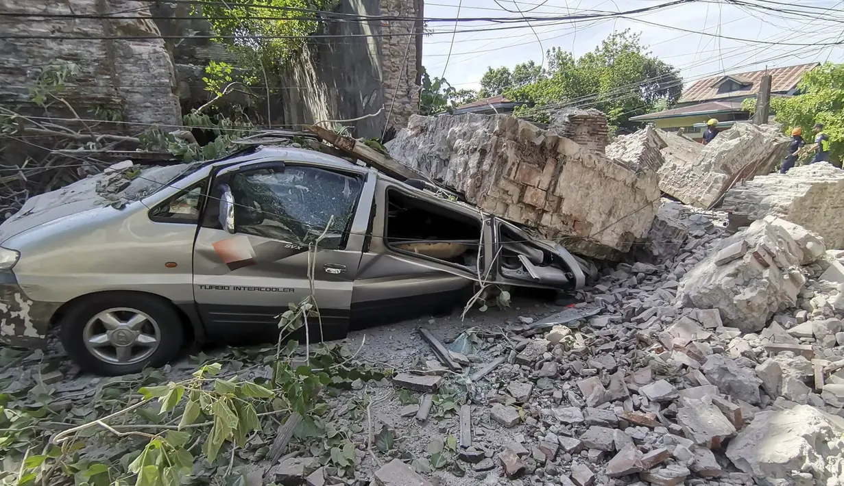 Sebuah kendaraan rusak tertimpa reruntuhan tembok menyusul gempa kuat yang melanda Vigan, Provinsi Ilocos Sur, Filipina, 27 Juli 2022. Dari empat orang yang tewas akibat gempa, sebagian besar ditemukan dalam bangunan yang runtuh. (Bureau of Fire Protection via AP)