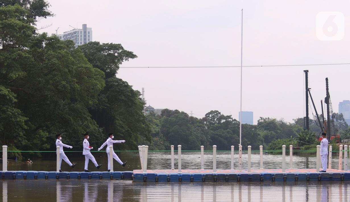 Anggota Paskibraka bersiap mengibarkan bendera merah putih di Sungai Cisadane, Kota Tangerang, Banten, Kamis (28/10/2021). Pengibaran bendera merah putih yang di ikuti puluhan pemuda tersebut di lakukan untuk memperingati hari sumpah pemuda. (Liputan6.com/Angga Yuniar)