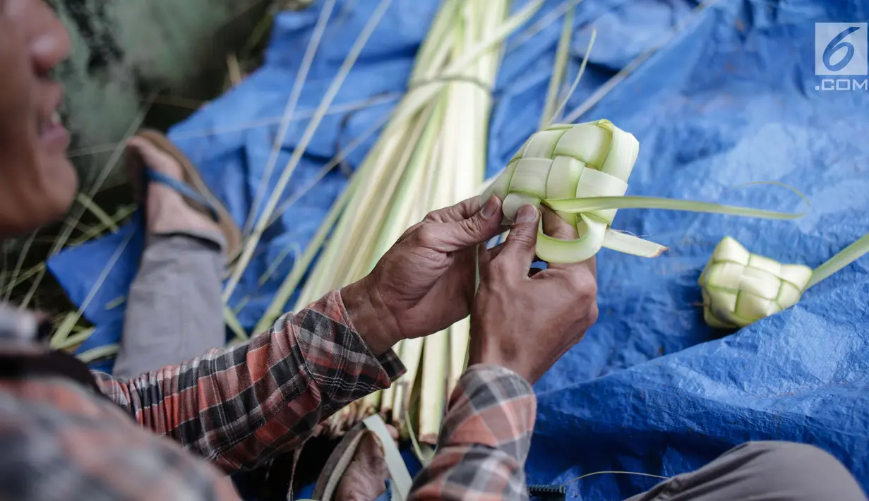 Pedagang sedang menganyam kulit ketupat di Pasar Palmerah, Jakarta, Rabu (2/6). Jelang lebaran penjualan kulit ketupat mulai ramai, omsetnya melonjak hingga 10 kali lipat. (Liputan6.com/Faizal Fanai)