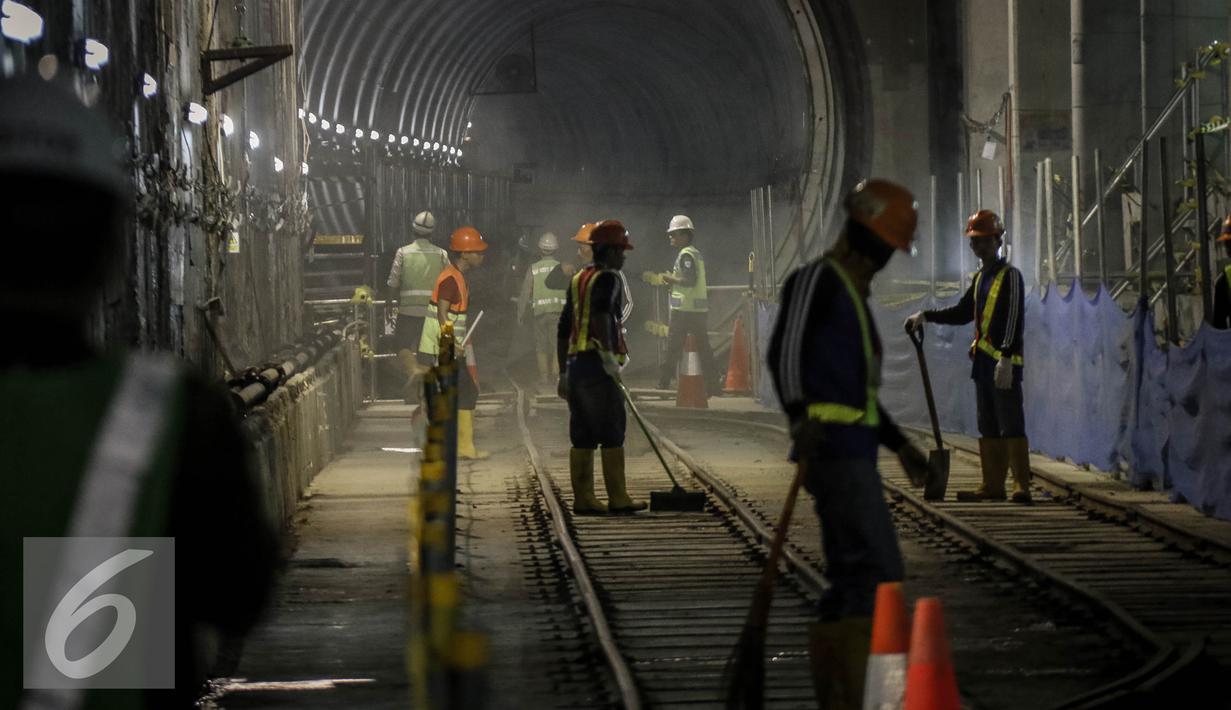 Para pekerja membersihkan jalur rel di terowongan Mass Rapid Transit (MRT) di Dukuh Atas, Jakarta, Jumat (30/9). Jumlah stasiun yang dilalui di rute tersebut sebanyak 13 stasiun. (Liputan6.com/Faizal Fanani)