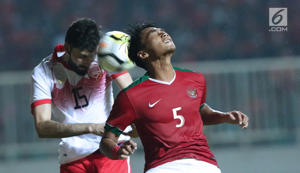 Gelandang Indonesia U-23, M Hargianto (kanan) berebut bola dengan pemain Bahrain, Hasan Alkarrani pada laga PSSI Anniversary 2018 di Stadion Pakansari, Kab Bogor, Jumat (27/4). Babak pertama Indonesia tertinggal 0-1. (Liputan6.com/Helmi Fithriansyah)