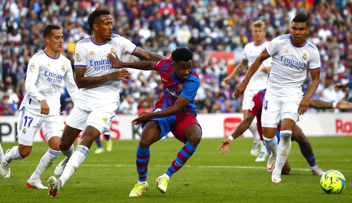Pemain Real Madrid Eder Militao (kiri) berebut bola dengan pemain Barcelona Ansu Fati (tengah) pada pertandingan La Liga Spanyol di Stadion Camp Nou, Barcelona, Spanyol, Minggu (24/10/2021). Real Madrid menang 2-1. (AP Photo/Joan Monfort)