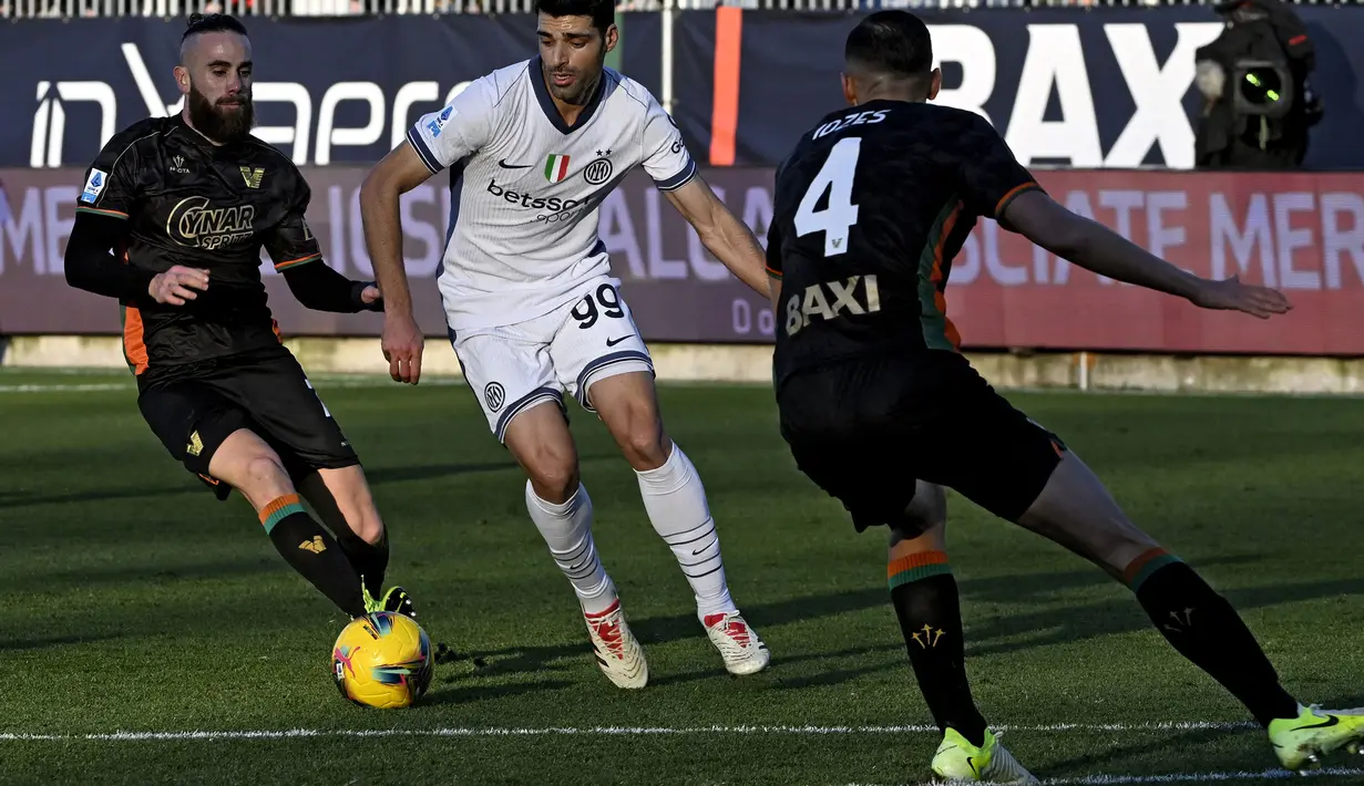Pemain Venezia, Jay Idzes (kanan) membayangi pergerakan pemain Inter Milan, Mehdi Taremi pada laga lanjutan Liga Italia 2024/2025 di Pier Luigi Penzo Stadium, Venice, Minggu (12/01/2025) malam WIB. (AFP/Andrea Pattaro)