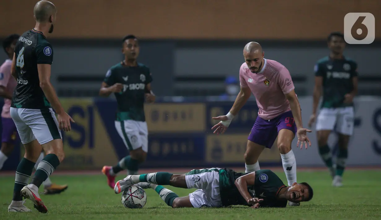 Ekspresi kesakitan gelandang Persikabo 1973, Manahati Lestusen (bawah) setelah beradu dengan penyerang Kediri Youssef Ezzejari saat laga pekan ketiga BRI Liga 1 2021/2022 di Stadion Wibawa Mukti, Cikarang, Jumat (17/09/2021). Persikabo dan Persik bermain imbang 2-2. (Bola.com/Bagaskara Lazuardi)