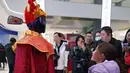 Pada pameran ini, pengunjung dapat menyaksikan berbagai jenis robot, termasuk humanoid dan yang berkaki empat (robot anjing), yang melakukan gerakan tarian untuk menyambut Tahun Baru Imlek 2577 Kongzili. Tampak dalam foto, seorang anak melihat robot humanoid yang berpakaian seperti Dewa Kekayaan selama pratinjau media pameran kuil robot yang dirayakan menjelang Tahun Baru Imlek di Beijing, China, Jumat 13 Februari 2026. (AP Photo/Vincent Thian)