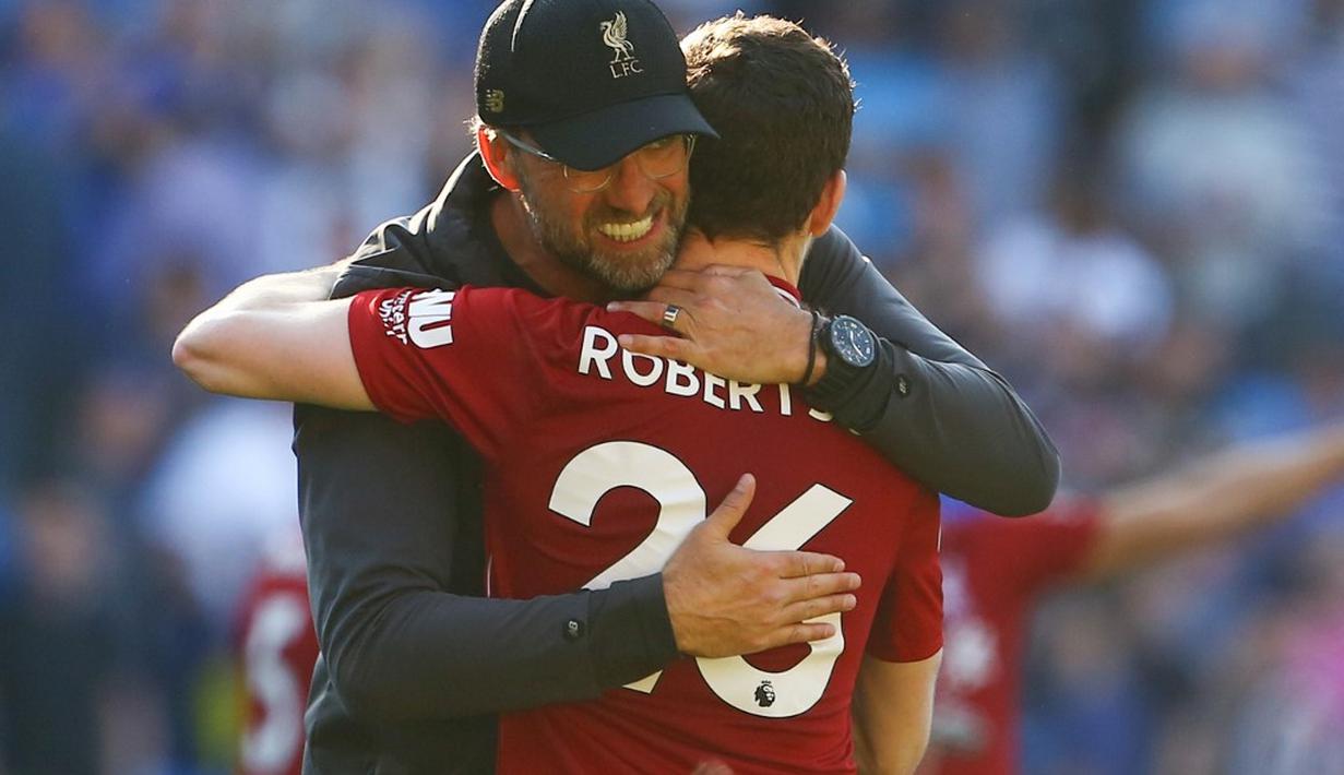 Jurgen Kloop berpelukan dengan Robertson usai pastikan kemenangan pada laga lanjutan Premier League yang berlangsung di Stadion Millenium, Cardiff, Minggu (21/4). Liverpool menang 2-0 atas Cardiff City. (AFP/Geoff Caddick)