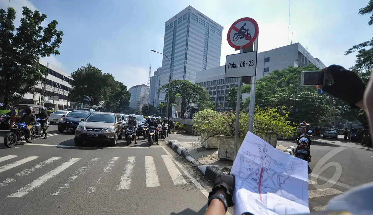 Petugas saat menujukan peta lokasi rambu larangan motor di Jalan Abdul Muis, Jakarta, Senin (6/4/2015). Pengendara sepeda motor diizinkan melintas mulai pukul 23.00 hingga 06.00 WIB. (Liputan6.com/Faizal Fanani)