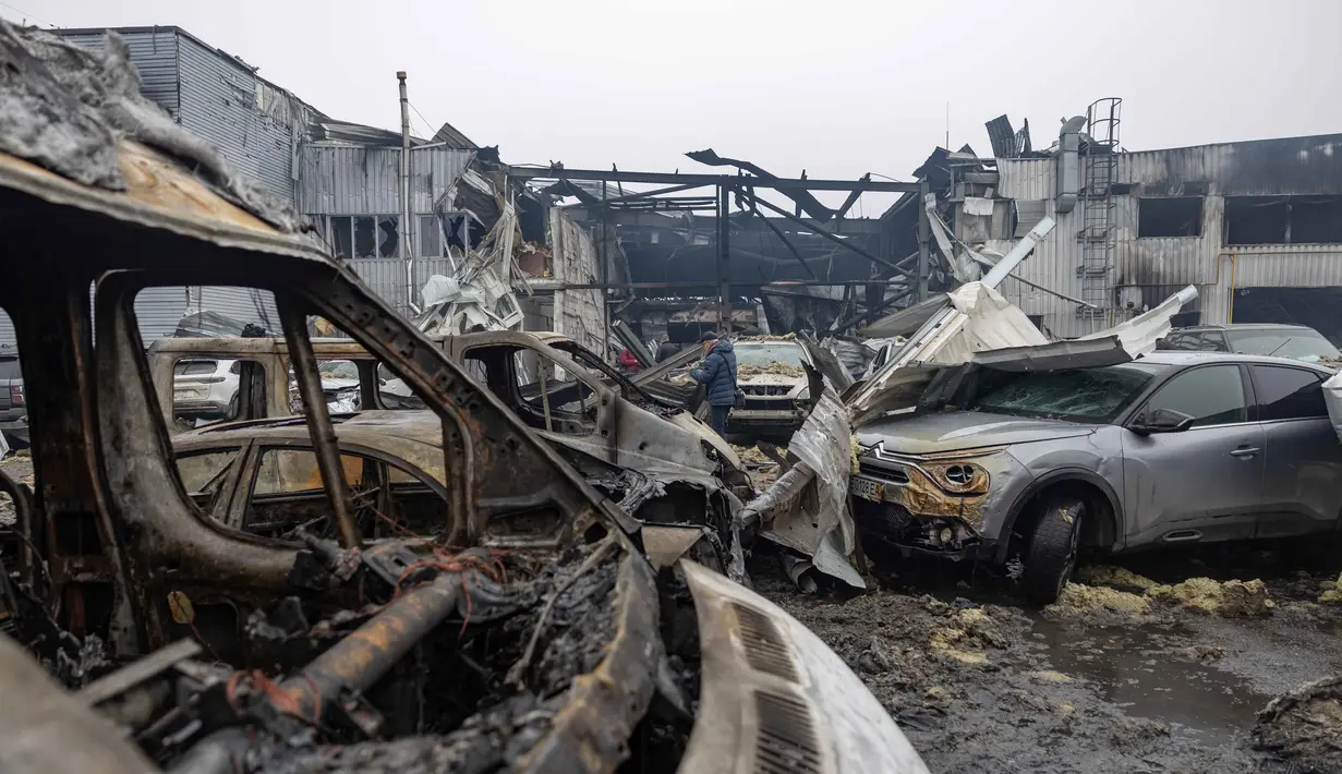 Serangan udara terbaru Rusia juga menyebabkan listrik dan air di ibu kota Kyiv, Ukraina, serta kota Dnipro dan Odesa tak bisa diakses. Tampak dalam foto, warga setempat memeriksa mobil-mobil yang rusak di Odesa pada Jumat 13 Februari 2026. (Oleksandr GIMANOV/AFP)