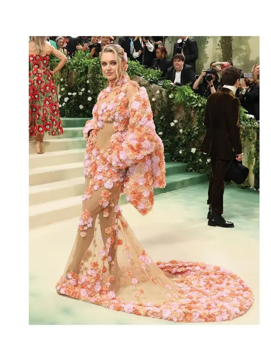 Kelsea Ballerini menampilkan salah satu penampilannya yang paling romantis  di Met Gala 2024 . Pelantun "IF YOU GO DOWN I'M GOIN' DOWN TOO" itu menghiasi karpet merah dalam balutan gaun nude bertabur bunga dari Michael Kors [@michaelkors]