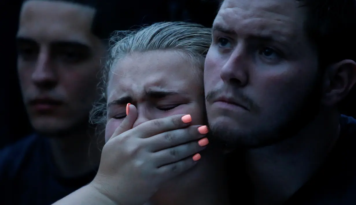 Savannah dipeluk oleh temannya saat memperingati korban penembakan di Pulse, klub malam khusus kaum gay di kota Orlando, Florida, AS, Minggu (12/6). Seorang pria bersenjata menyandera sejumlah orang setelah menembaki klub gay itu. (REUTERS/Adrees Latif)