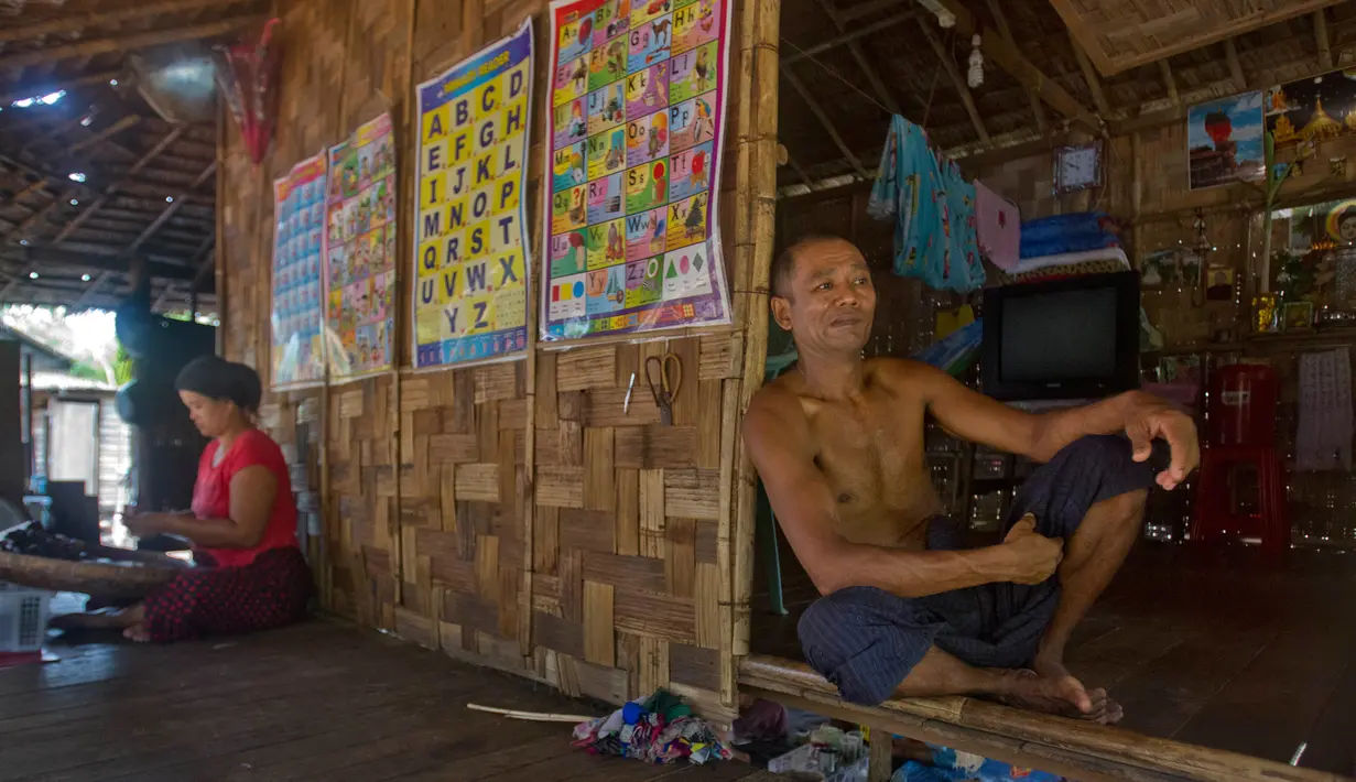 Mantan korban perbudakan Myint Naing, beristirahat dekat adiknya Molly Than yang membuat rokok tradisional di rumah Than, Mudon, Myanmar, 8 April 2017. (AP Photo/Thein Zaw)