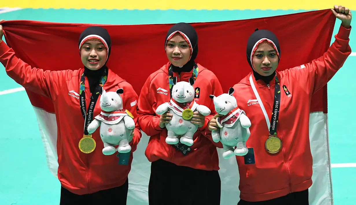 Tim pencak silat seni beregu putri Indonesia, Pramudita Yuristya (kiri), Lutfi Nurhasanah (tengah) dan Gina Tri Lestari (kanan) berpose usai meraih medali emas Asian Games 2018, Jakarta, Rabu (29/8). (ANTARA FOTO/INASGOC/Melvinas Priananda/nak/18)