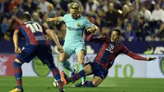 Gelandang Barcelona, Ivan Rakitic berebut bola dengan pemain Levante, Sasa Lukic pada jornada ke-37 La Liga di Estadio Ciudad de Valencia, Senin (14/5). Barcelona gagal menjaga rekor tak terkalahkan musim ini pada ajang La Liga Spanyol. (AFP/JOSE JORDAN)