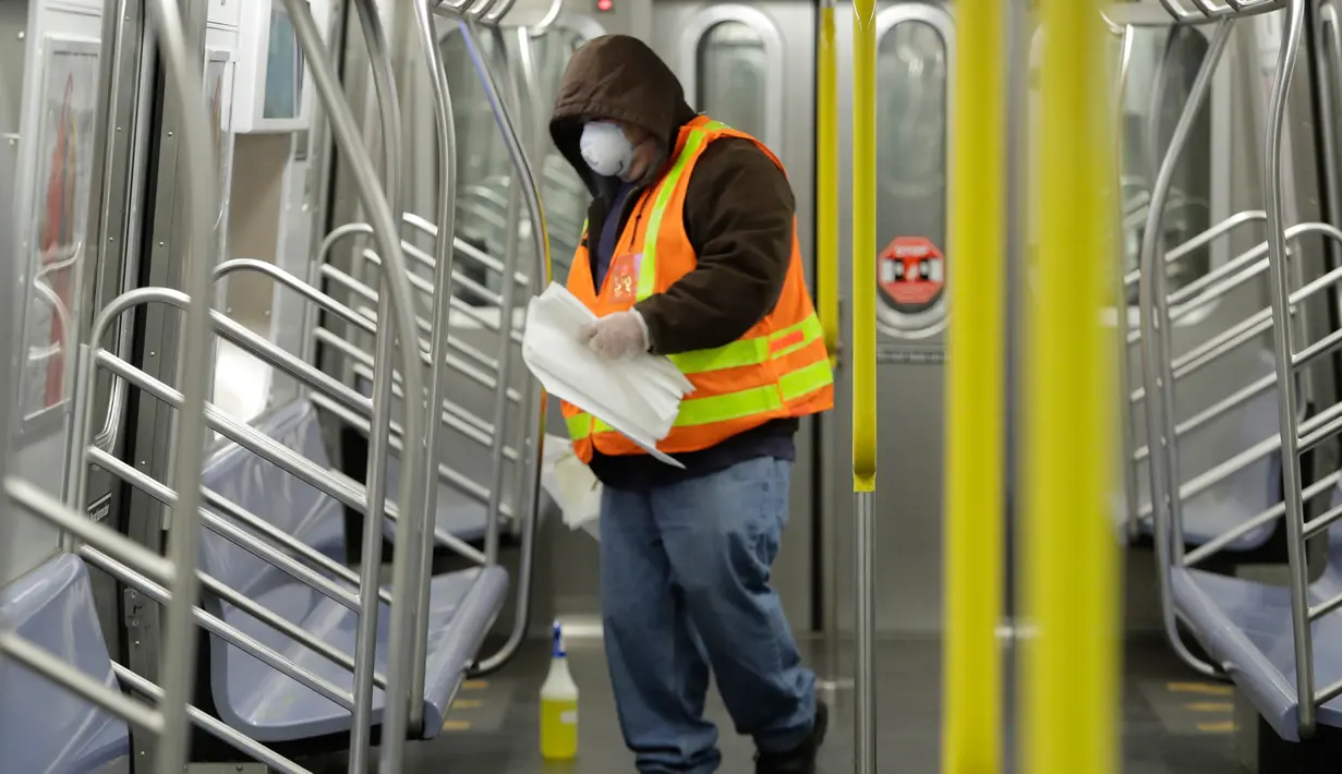 Pekerja otoritas transportasi kota New York mendisinfeksi gerbong kereta bawah tanah di stasiun Coney Island di Brooklyn, Rabu (6/5/2020). Untuk pertama kalinya, sistem kereta bawah tanah New York dimatikan sementara untuk dibersihkan guna menghentikan penyebaran virus corona. (AP/Frank Franklin II)