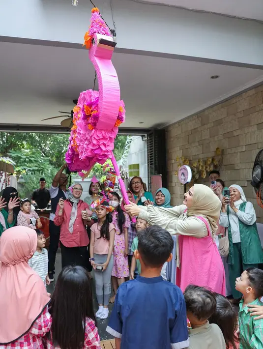 Suasana kemeriahan ulang tahun Baby Amala. Setelah doa bersama dan tiup lilin lanjut pukul pinata berbentuk flamingo. [Instagram/_irishbella_]